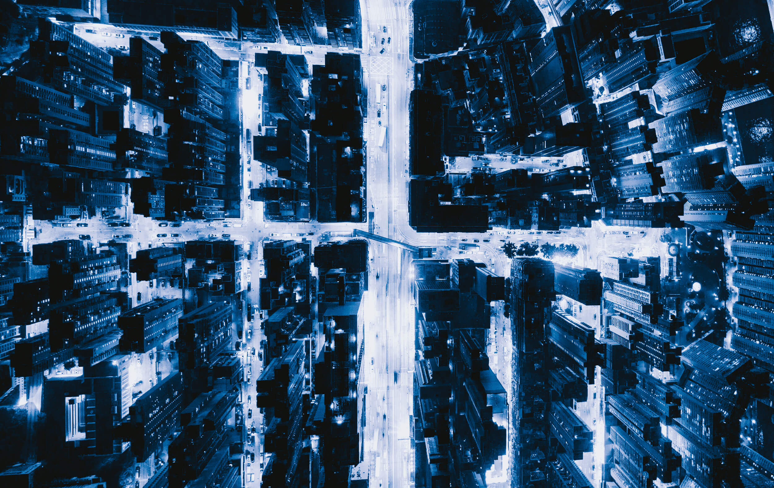 Aerial night view of a metropolis with illuminated street intersections in blue tones