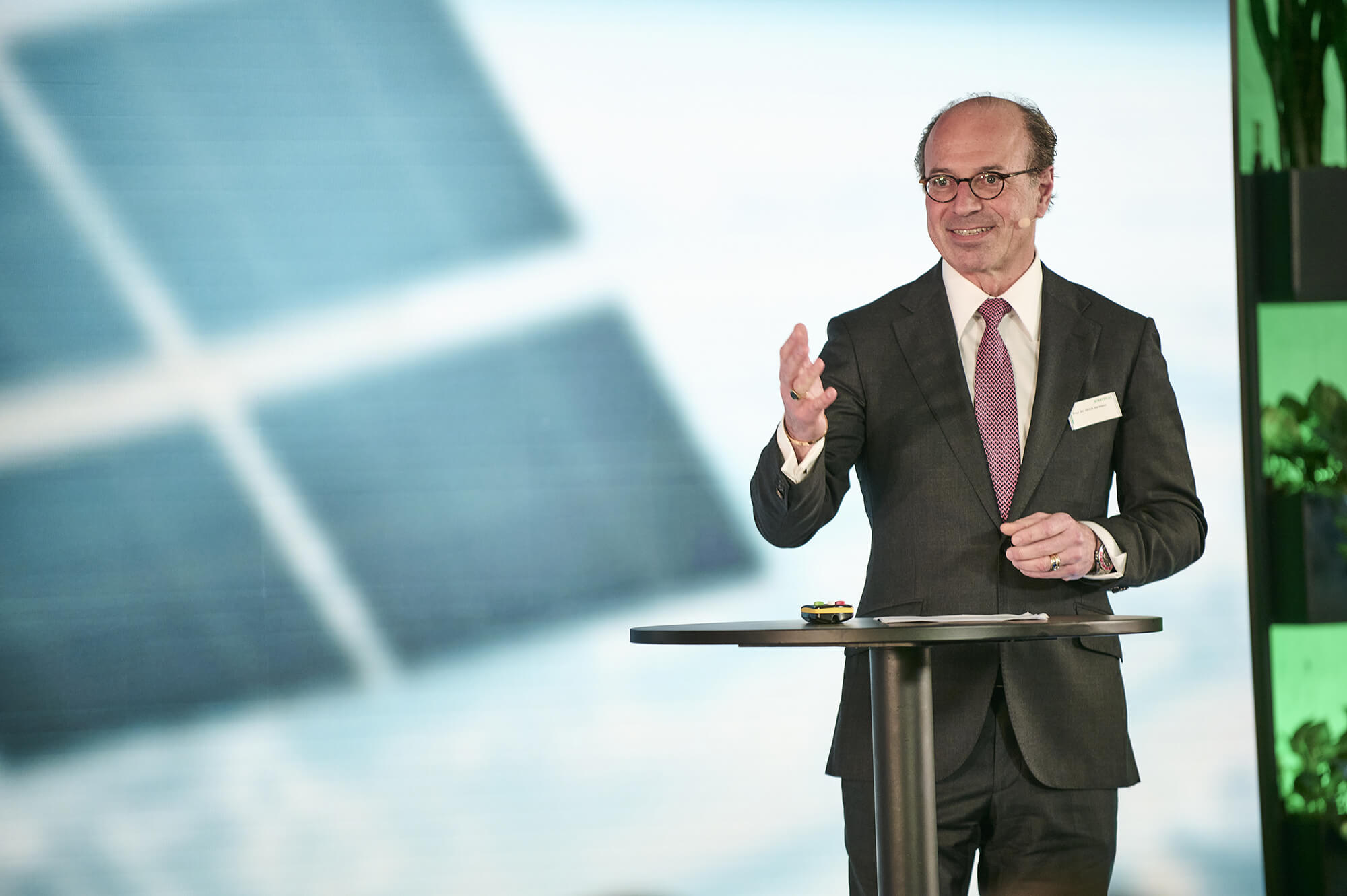 Ulrich Hermann gesturing at a standing table during his presentation at the 1st Schaeffler Tech Talk.