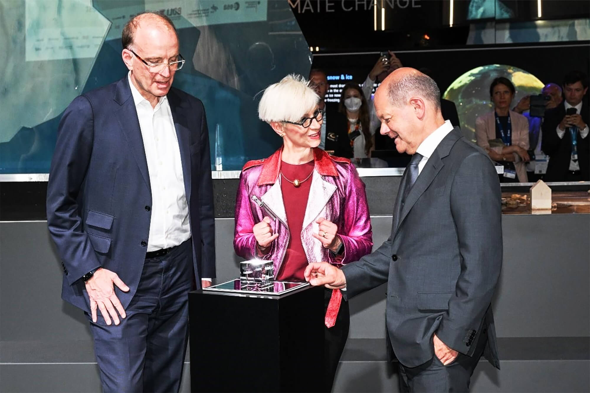 Marco Fuchs präsentiert dem ehemaligen Bundekanzler Olaf Scholz ein Exponat auf einer Raumfahrt- und Klimakonferenz.